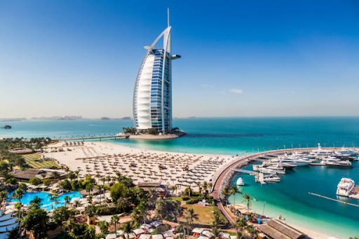 Aerial view of Burj Al Arab and Dubai coastline, illustrating the allure of living and working in Dubai.